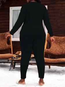 Vue arrière d'un ensemble pyjama thermique noir dans un chalet d'hiver chaleureux