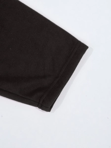 Gros plan du tissu de pyjama thermique noir montrant les coutures fines et la texture