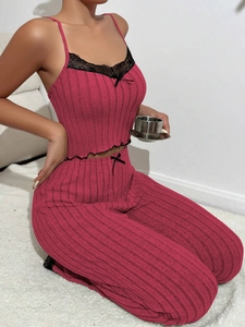 Detail of fuchsia ribbed loungewear set featuring black lace trim and delicate bow accent