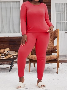 Détail de l'ensemble de pyjama thermique rouge sur un fond de chalet enneigé extérieur