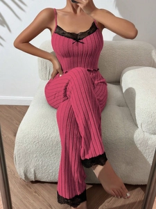 Detail of rose pink ribbed loungewear with delicate black lace trim and bow accent