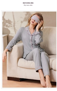 Detail of grey pajama set with pink piping including long-sleeve top pants and eye mask