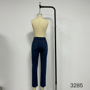 Dettaglio dei jeans blu scuro a vita alta con tasche posteriori classiche e bordo grezzo