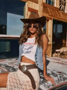 Gilet en jean vintage pour femmes porté avec un t-shirt graphique et un chapeau de cowboy