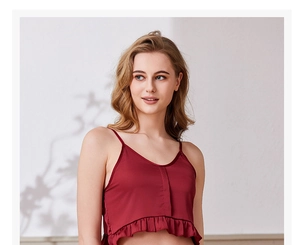 Dettaglio del camisole in raso rosso vino con raffinati volant e spalline sottili