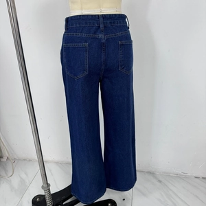 Détail des poches arrière et de la texture en denim délavé du jean ample à taille haute