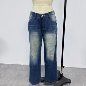 Detail showing vintage washed blue denim texture and silver metal button closure