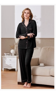 Detail of charcoal grey knit pajamas with pink contrast piping and Love embroidery