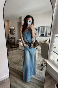 Détail d'une jupe longue en jean bleu clair avec ourlet brut et fini délavé