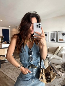 Détail d'un gilet en jean bleu foncé rétro avec boutons en métal et col en V profond