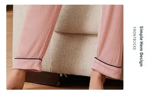 Detail of pink ribbed pajama pants hem featuring minimalist design and black piped edge