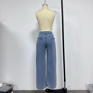 Détail de la couture de la poche arrière en forme de cœur sur un jean bleu clair
