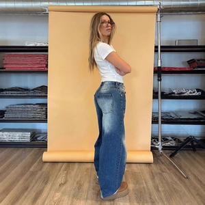 Detail of wide-leg blue jeans with retro washed finish and classic pocket design