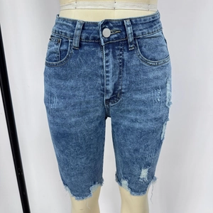Détail d'un short en jean montrant la texture déchirée et l'ourlet effiloché à bord brut