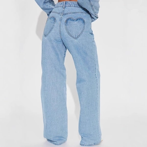 Détail des poches arrière en forme de cœur sur un jean large bleu clair taille haute
