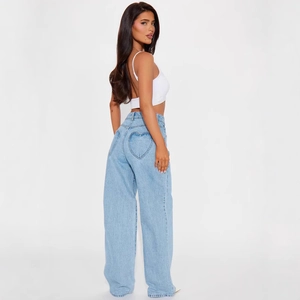 Détail du jean taille haute à jambe large avec broderie de poche en forme de cœur au dos