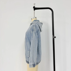 Detail der hellblauen Jeansjacke mit Kapuze, Seitentaschen und elastischem Saumdesign