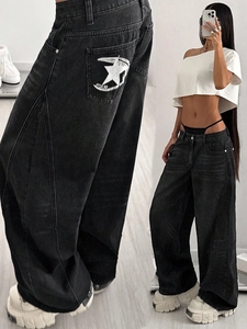 Close-up of star embroidery on vintage grey high-waisted wide-leg denim jeans for women