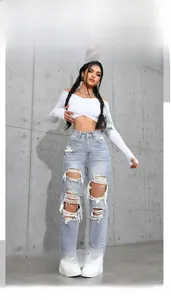 Detail of ripped light blue high-waisted jeans with distressed fringes in street style