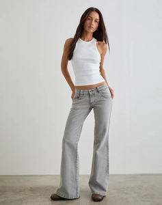 Détail d'un jean évasé moulant associé à un débardeur blanc côtelé pour un style urbain