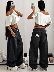 Detail of high waist wide leg jeans featuring white star embroidery on the back pocket