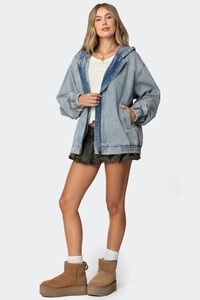 Detail einer hellblauen Oversized-Jeansjacke mit Kapuze, Reißverschluss und Wascheffekt