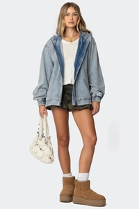Detail der hellblauen Jeansjacke mit Kapuze, Reißverschluss und elastischen Bündchen