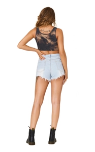 Detail of distressed denim shorts with raw hem and classic lace-up black leather boots