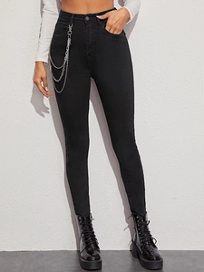 Detail einer schwarzen High-Waist-Skinny-Jeans mit dekorativen dreifachen Silberketten