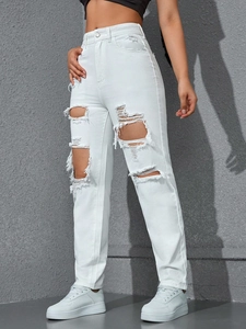 Detail shot of distressed white high waist jeans with oversized ripped knees and raw edges