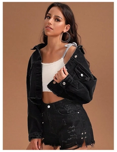 Détail de l'ourlet brut et des boutons en métal vintage sur veste et short en jean noir