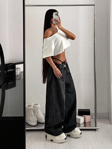 Mirror selfie showing high waisted distressed black wide leg jeans with white crop top