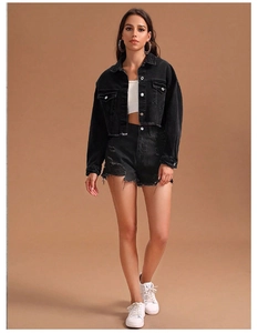 Détail de veste courte en jean noir et short effiloché avec finition délavée vintage