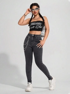 Detail der grauen Skinny-Jeans mit hoher Taille und modischer silberner Metallketten-Deko