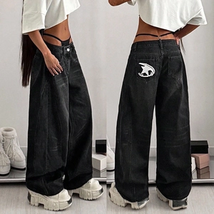 Detailed view of vintage washed black wide leg jeans with white star embroidery on back pocket