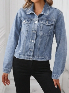 Detailed texture of light blue denim jacket featuring metal buttons and flap pockets