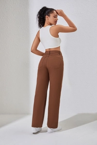 Vue détaillée d'un jean marron taille haute et d'un débardeur blanc dos nu chic