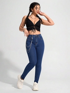 Detail von High-Waist-Skinny-Jeans mit silbernen Metallketten und Stretch-Stoff