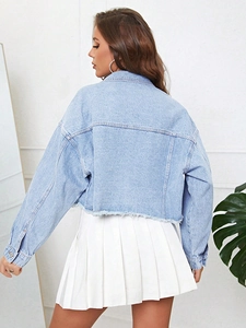 Détail d'une veste en jean bleu clair avec épaules tombantes et ourlet brut effiloché