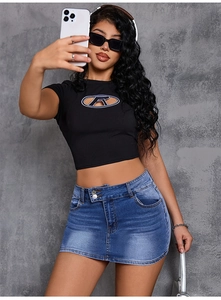 Detail of blue washed denim mini skirt paired with a black cutout crop top