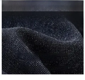 Macro shot of high-density blue denim fabric with twill weave and washed texture details