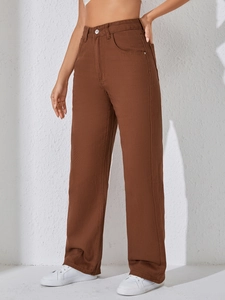 Détail du pantalon en jean marron à taille haute et jambe large avec boutons métalliques