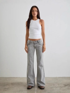 Jean évasé gris clair coupe slim avec débardeur blanc côtelé pour un style décontracté