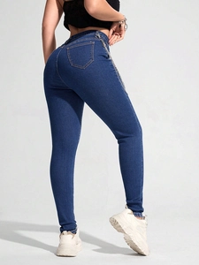 Detailaufnahme der High-Waist Skinny Jeans in Blau mit silberner Metallkette an der Hüfte