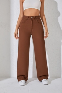 Détail d'un pantalon en jean marron à taille haute et jambe large avec poches latérales