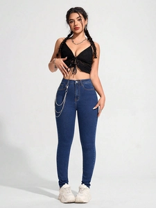 Detail von High-Waist-Skinny-Jeans mit mehrlagigen Metallketten und Streetstyle-Ästhetik