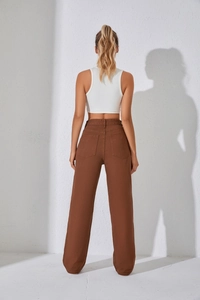 Vue détaillée des poches arrière et de la taille haute d'un jean marron à jambes larges pour femme