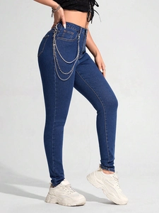 Detail der High-Waist-Skinny-Jeans mit dreifacher silberner Metallkette an der Hüfte