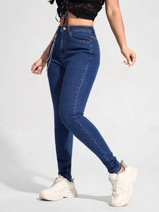 Detailansicht der High Waist Skinny Jeans in Blau mit dekorativer Metallkette am Bund
