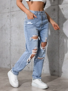 Detail view of high waist distressed light blue denim jeans with ripped knee design